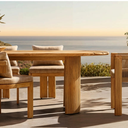 Wooden outdoor dining table and chairs with a scenic ocean view.