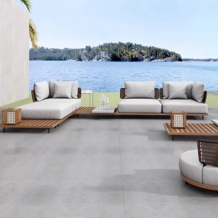 Outdoor patio furniture set with cushions by a waterfront.