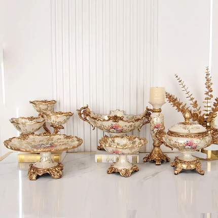 Set of ornate gold and silver decorative pieces on a marble surface with a white wall background.