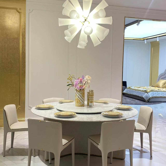 Elegant Modern Dining Room Featuring a Round Marble Table and  White Upholstered Chairs Gold-Accented Dinnerware and Luxurious