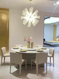 Elegant Modern Dining Room Featuring a Round Marble Table and  White Upholstered Chairs Gold-Accented Dinnerware and Luxurious