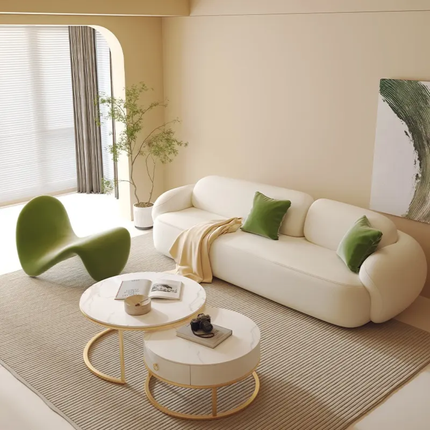 Modern living room with a white sofa, green chair, and round coffee table.