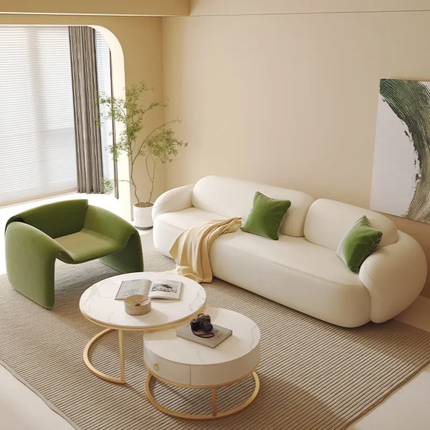 Modern living room with a white sofa, green armchair, and round coffee table.