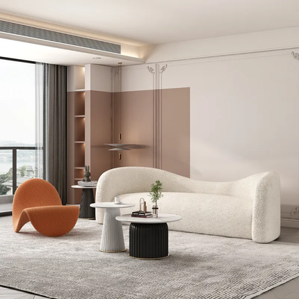 Modern living room with a white sofa, orange chair, and glass wall.