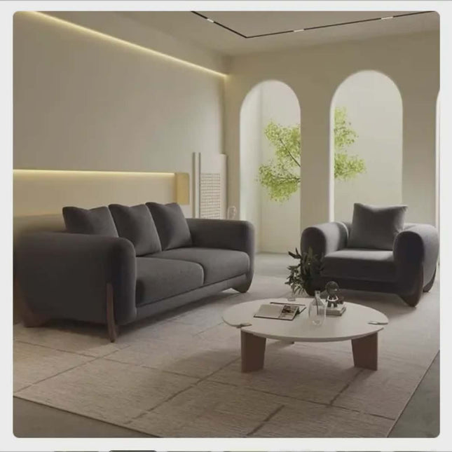 Modern living room with gray sofa, armchair, and coffee table.