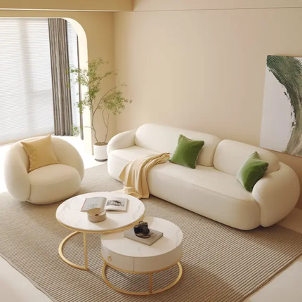 Modern living room with a white sofa, round coffee table, and decorative pillows.