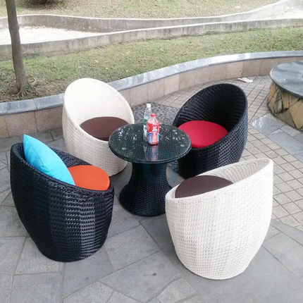 Outdoor furniture set with wicker chairs and a small table on a patio.