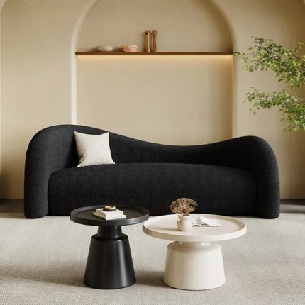 Modern black sofa in a living room with two coffee tables.