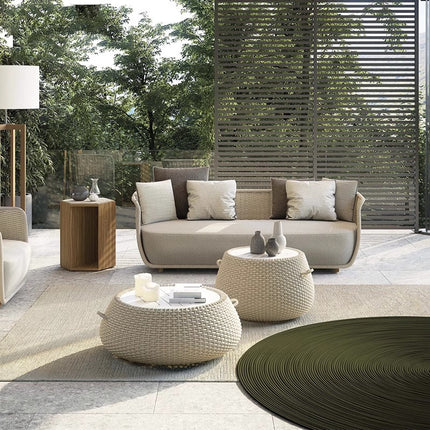 Outdoor patio with modern furniture including a sofa, ottomans, and a coffee table.