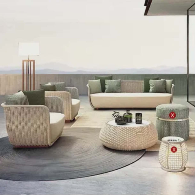 Modern outdoor furniture set with beige and green cushions on a patio.