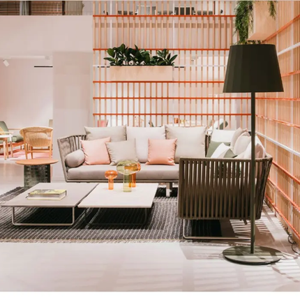 Modern living room with gray sofa, pink cushions, and decorative items.