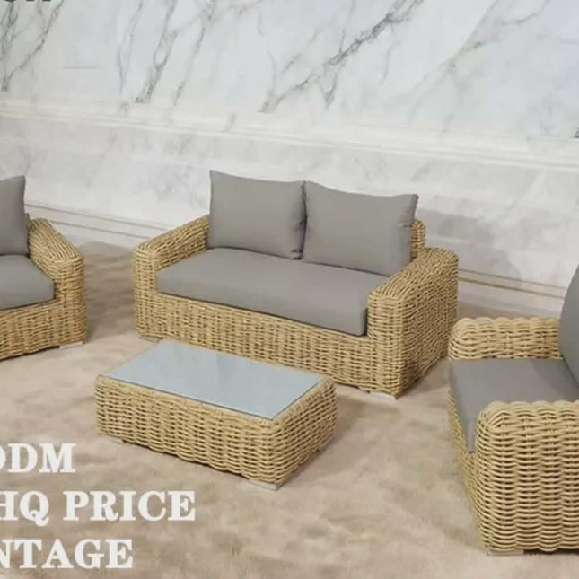 Wicker outdoor furniture set with gray cushions on a marble floor.