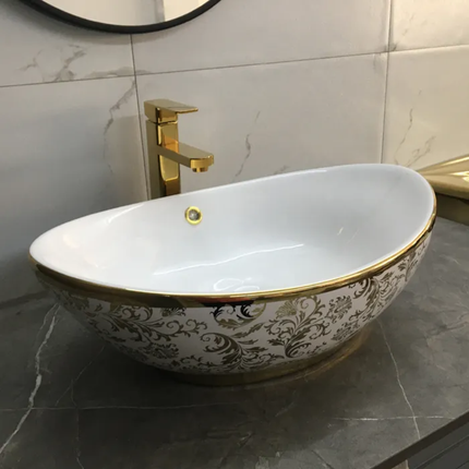 Decorative oval sink with gold accents in a bathroom setting