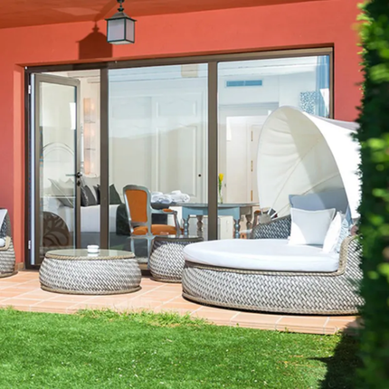 Outdoor patio area with modern furniture and sliding glass door.