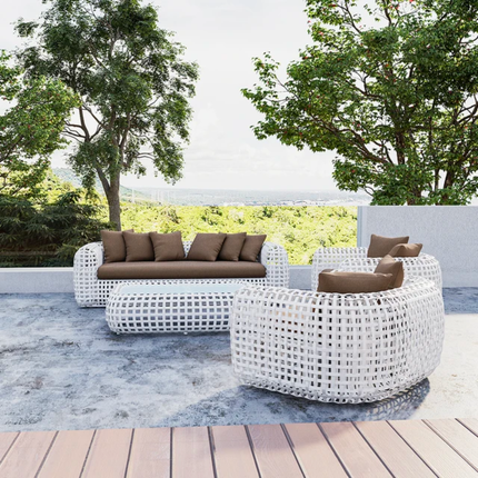 Outdoor patio set with white wicker furniture and brown cushions on a wooden deck.