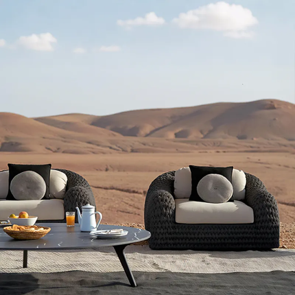 Modern outdoor furniture set with cushions against a desert landscape