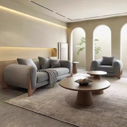Modern living room with gray sofa, armchair, and round coffee table.