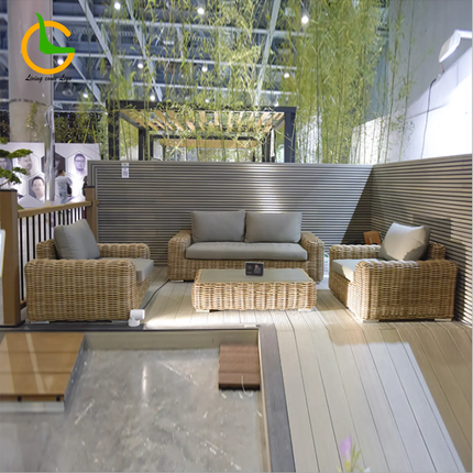 Wicker outdoor furniture set with cushions in a modern indoor setting.