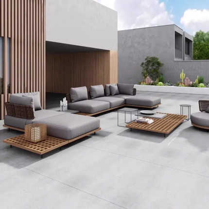 Modern outdoor patio furniture set with gray cushions on a concrete patio.