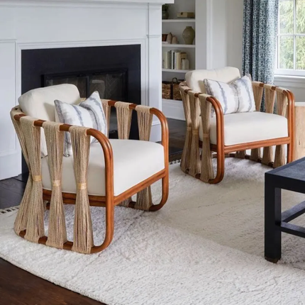 Two wooden armchairs with white cushions in a living room setting.