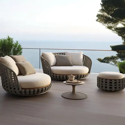 Outdoor patio furniture set with cushions on a deck overlooking water.