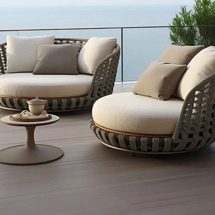 Outdoor patio furniture set with wicker chairs and cushions on a wooden deck.