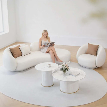 Woman sitting on a modern white sofa in a minimalistic living room.