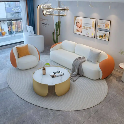Modern living room with a white and orange sofa, round coffee table, and decorative elements.
