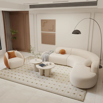 Modern living room with a curved white sofa, round coffee table, and decorative pillows.