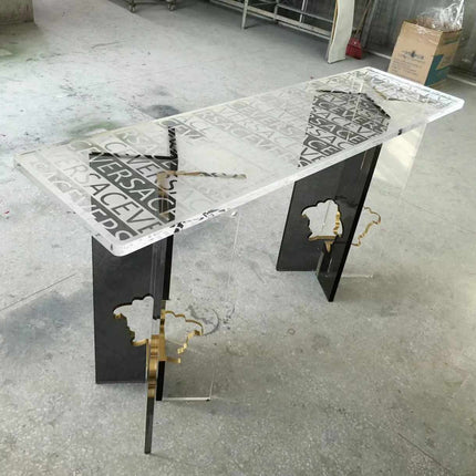 Versace Clear Surface Clarity Table Bold Typography Encased in Crystal Luxury and Contemporary Style Perfect for Elevating High-Fashion Flair  A Striking Centerpiece That Captures the Essence of Versace's Iconic Branding