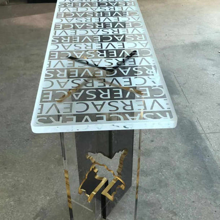 Versace Clear Surface Clarity Table Bold Typography Encased in Crystal Luxury and Contemporary Style Perfect for Elevating High-Fashion Flair  A Striking Centerpiece That Captures the Essence of Versace's Iconic Branding