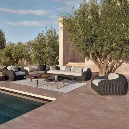 Outdoor patio with wicker furniture, pool, and trees