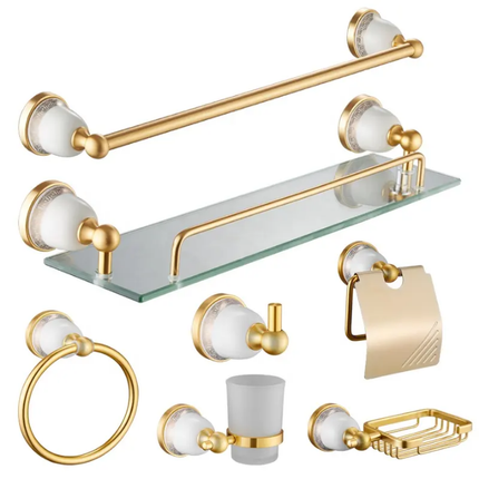 Gold and white bathroom accessory set including towel bar, shelf, toilet paper holder, and hooks on a white background.