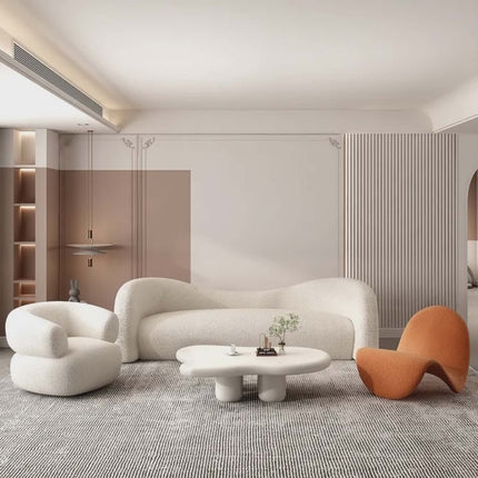 Modern living room with a white sofa, orange chair, and round coffee table.