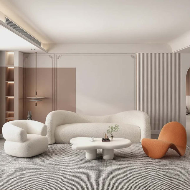 Modern living room with a white sofa, orange chair, and round coffee table.
