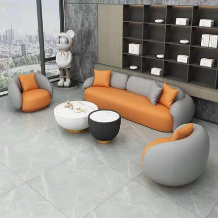 Modern living room with orange and gray sofa set, coffee table, and decorative items.
