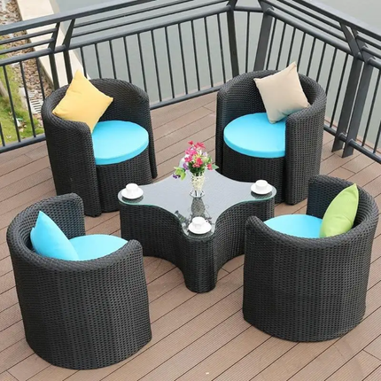 Outdoor furniture set with four chairs and a glass table on a wooden deck.