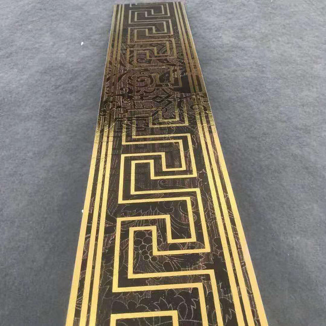 A box of luxury black and gold border tiles with a geometric pattern.