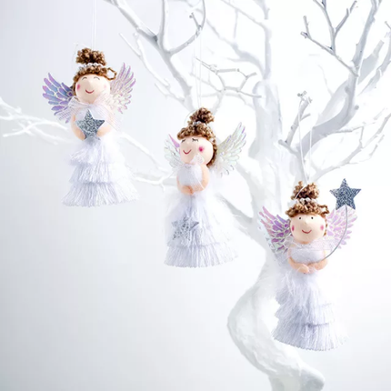 Three white angel figurines with decorative details, hanging from a Christmas tree.