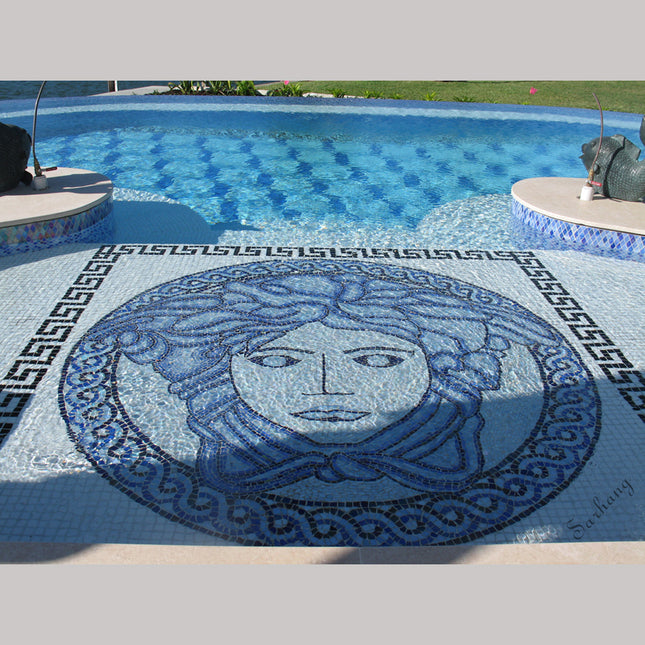 A swimming pool with a colorful glass mosaic tile pattern featuring a geometric design and a central figure's face.