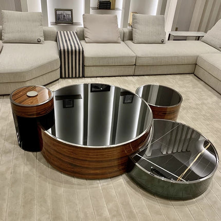 A stainless steel frame high gloss tempered glass coffee table with a wooden element, displayed in a modern living room setting.
