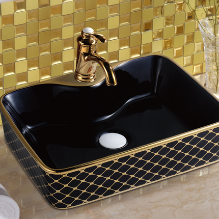 Salle de bain de luxe avec lavabo en porcelaine noire et or, lavabo et WC.