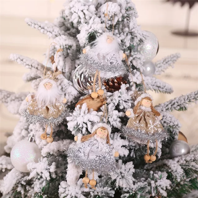 A set of decorative dolls designed for Christmas tree ornaments, featuring snow-themed outfits and hanging from the branches of a decorated tree.